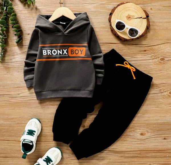Gray hoodie with Bronx Boy text and black pants with orange drawstring on wooden floor, kids tracksuit outfit