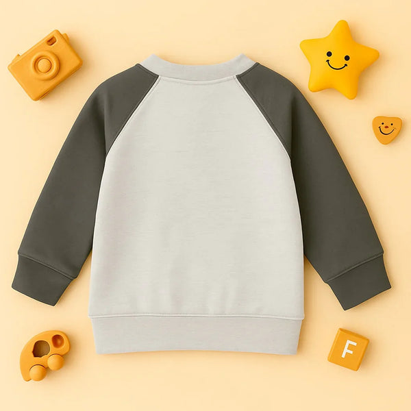 Grey and off-white raglan sweatshirt for kids on beige background with yellow smiley star and toy camera