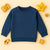 Zinc blue knitted pattern children's sweatshirt with ribbed cuffs on cream background with wooden toys