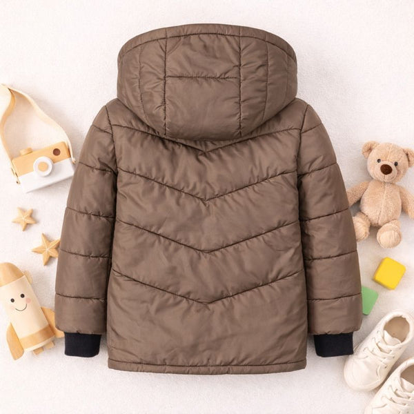 Brown kids puffer jacket with hood, black cuffs, displayed flat with toys and white shoes around